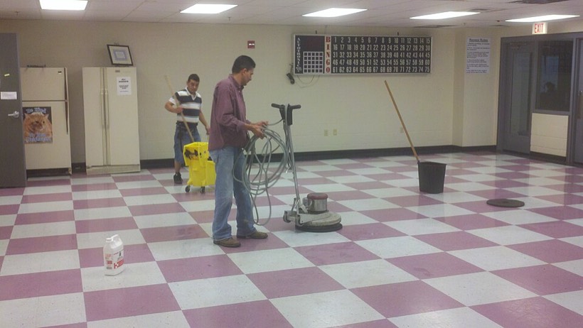 Worker cleaning a floor with a floor machine
