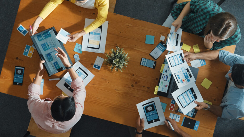 a group of people sitting around a table with paper on them